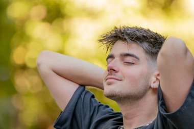 Rahat genç adam dışarıda nefes alıyor.