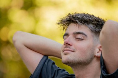 Rahat genç adam dışarıda nefes alıyor.