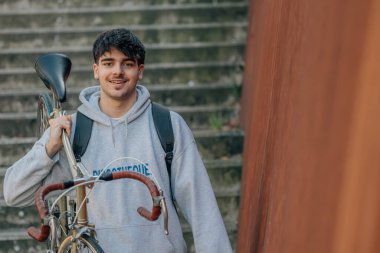 Bisiklet taşıyan öğrenci