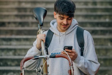 Bisiklet taşıyan cep telefonu olan öğrenci.