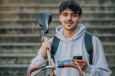 Bisiklet taşıyan cep telefonu olan öğrenci.