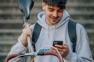 Bisiklet taşıyan cep telefonu olan öğrenci.