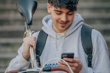 Bisiklet taşıyan cep telefonu olan öğrenci.