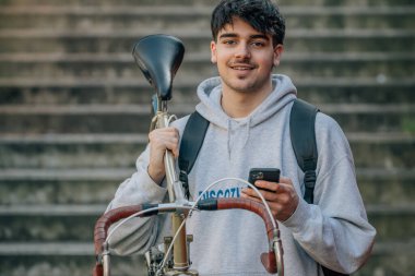 Bisiklet taşıyan cep telefonu olan öğrenci.