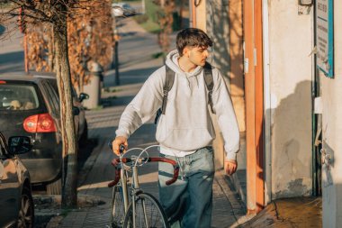 Sokakta klasik bir bisikletle yürüyen bir öğrenci.