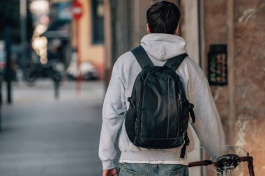 Sokakta klasik bir bisikletle yürüyen bir öğrenci.