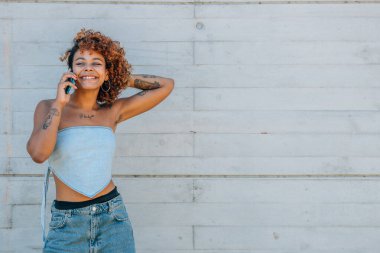 Gülümseyen Latin kız cep ya da cep telefonuyla konuşuyor