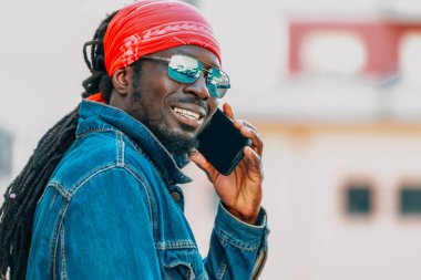 Sokakta cep telefonuyla konuşan Afrikalı bir adam