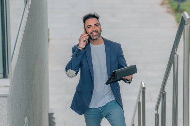 Sokaklarda tablet ve cep telefonu olan bir işadamı.