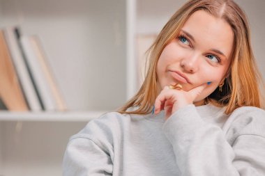 Genç mavi gözlü sarışın kadın ya da evdeki öğrencinin portresi.