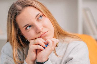 Genç mavi gözlü sarışın kadın ya da evdeki öğrencinin portresi.