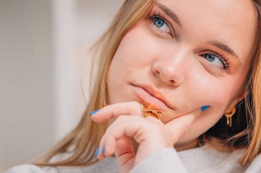 Genç mavi gözlü sarışın kadın ya da evdeki öğrencinin portresi.