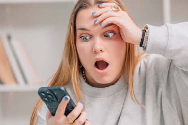 Genç sarışın kadın ya da mavi gözlü, cep telefonlu ve şaşkın bakışlı öğrenci.