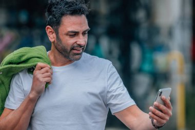 Sokaktaki cep telefonlu genç adam.