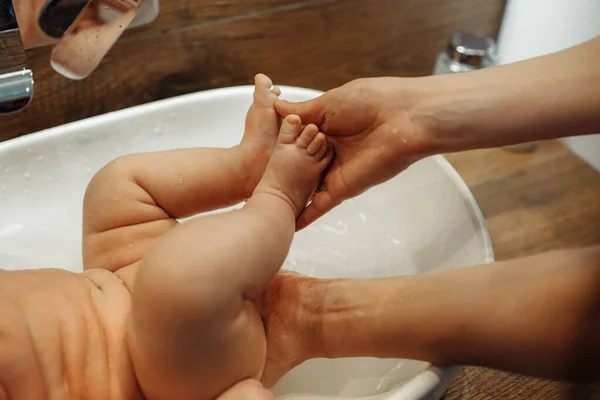Купання Маленької Дитини Умивальнику Мама Тримає Дитячі Ноги Високоякісна Фотографія — стокове фото