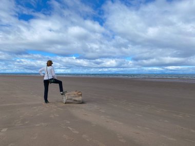 Covesea, İskoçya - 7 Ağustos 2022: Yalnız kadın Moray Sahil Yolu. Kuzeydoğu İskoçya 'da Moray konsey bölgesinin kıyı şeridi boyunca uzanan uzun bir yol.