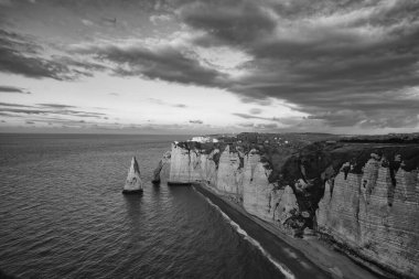 Etretat sahillerinde inanılmaz bir gün batımı. Panorama filmi. Etretat, Alabaster Sahili 'nin büyüleyici uçurumları ve Normandiya' nın en popüler turistik alanlarından biri olan Etretat 'ın büyüleyici bir kasabasıdır..