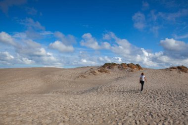 Skagen, Danimarka - 14 Ağustos 2018 Rabjerg Mile 'da yalnız bir kadın. Skagen ve Frederikshavn arasında göç eden bir kumuldur. Kuzey Avrupa 'nın en büyük hareket eden kum tepesidir ve deniz seviyesinden 40 metre yüksekliğe sahiptir..