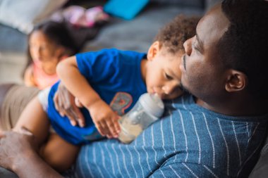 Genç milenyum babası evinde, oğlu kanepede.