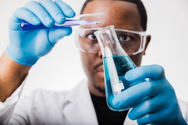 Laboratuvarda deney tüpleri ve deney tüpleriyle çalışan Afrikalı Amerikalı bilim adamı.