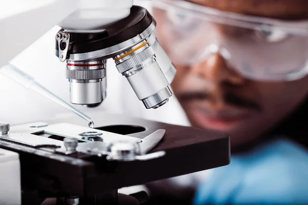 アフリカ系アメリカ人の科学者が顕微鏡を使って — ストック写真