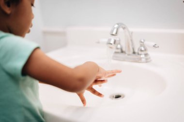 Evde banyo temizliği, lavabo temizliği, el yıkama, angarya ve hijyen işleri yapan çeşitli anaokulu kızları var.