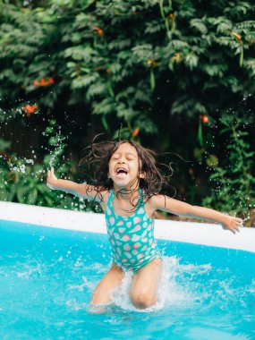 Sıcak yaz günlerinde evde çeşitli anaokulu kızları bahçede çocuk havuzunda eğleniyor.
