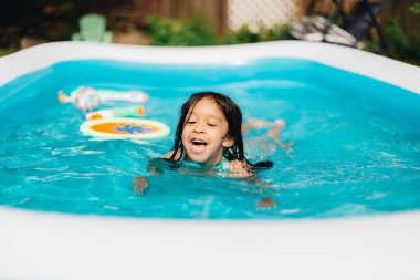 Sıcak yaz günlerinde evde çeşitli anaokulu kızları bahçede çocuk havuzunda eğleniyor.