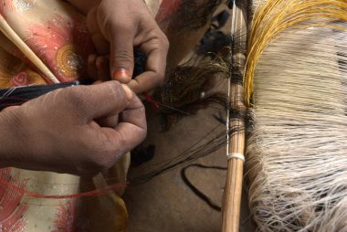 Hintli erkek işçi geleneksel bir ipek sari örüyor. Hindistan 25 Mayıs 2024