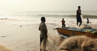 Kakinada Andhra Pradesh 'in 22 Şubat 2025' te denizden tekneyi çıkaran bir grup balıkçı.