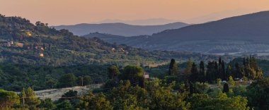 Tuscany, İtalya 'da günbatımı. Tepelerin panoramik manzarası.