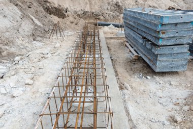 Metal takviyeli monolitik bir temel. Takviye inşaat ağı. Yeni inşaat inşaatı tamamlandıktan sonra beton yığını. Monolitik çalışmalar için bir inşaat aracı.