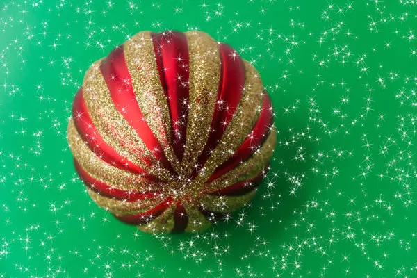 Parlak Yıldızlı Yeşil Arka Planda Kırmızı Bir Noel Topu Noel — Stok fotoğraf