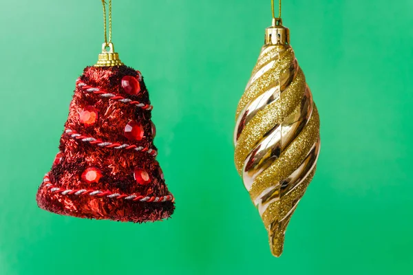 Две Рождественские Елки Украшения Зеленом Фоне Красный Колокол Золотые Сосульки — стоковое фото