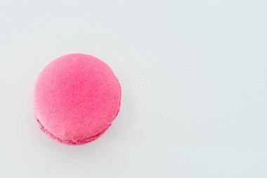 Beyaz arka planda izole edilmiş pembe Fransız makaronu. Lezzetli renkli badem kurabiyeleri. Kurabiye iki pürüzsüz yarıdan yapılmış, ince dolgularla bağlanmış. Yumurta beyazından yapılmış Fransız pastası..