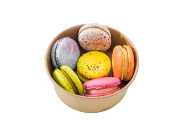 Beyaz arka planda izole edilmiş karton bir kutuda renkli badem kurabiyeleri ya da makaronlar. Lezzetli badem kurabiyeleri. Yumurta beyazından yapılmış Fransız pastası. Aşçılık ve aşçılık konsepti.