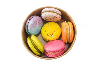 Beyaz arka planda izole edilmiş karton bir kutuda renkli badem kurabiyeleri ya da makaronlar. Lezzetli badem kurabiyeleri. Yumurta beyazından yapılmış Fransız pastası. Aşçılık ve aşçılık konsepti.