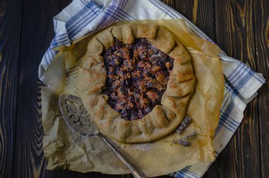 Erik meyveli turta crostata siyah ahşap masa üzerinde keten kumaş ve antika gümüş çatal bıçak yemek fotoğrafçılık