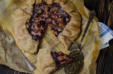 Erik meyveli turta crostata siyah ahşap masa üzerinde keten kumaş ve antika gümüş çatal bıçak yemek fotoğrafçılık