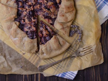 Erik meyveli turta crostata siyah ahşap masa üzerinde keten kumaş ve antika gümüş çatal bıçak yemek fotoğrafçılık