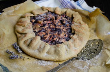 Erik meyveli turta crostata siyah ahşap masa üzerinde keten kumaş ve antika gümüş çatal bıçak yemek fotoğrafçılık