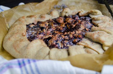 Erik meyveli turta crostata siyah ahşap masa üzerinde keten kumaş ve antika gümüş çatal bıçak yemek fotoğrafçılık