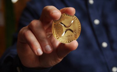 Dalgalanan XRP kripto altın sikke elde soyut konsept