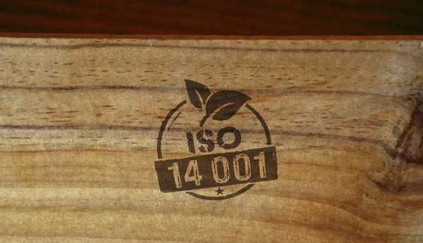 ISO 14001 certified stamp printed on wooden box. Environment ecology standard certificate concept.