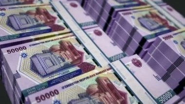 Özbekistan parası Özbek Sum para paketi 3D animasyon döngüsü. Döngüsüz finans, nakit, ekonomi, iş ve banka kavramı. Kamera 50000 UZS banknot destesinin üzerinde hareket ediyor.