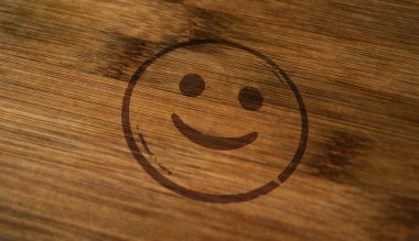 Tahta kutuya basılmış gülen yüz simgesi sembolü damgası. Gülümse emoji konsepti.