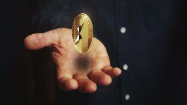 ThorChain RUNE kripto para birimi elinin üzerinde 3D para dönüyor. Elinde sembolü olan bir iş adamı. İş ve teknoloji kusursuz ve soyut kavramlarla donatılmış.