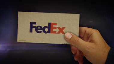 Poznan, Polonya, 12 Mart 2024, Fedex teslimat kutusu ellerinde. Federal ekspres nakliye şirketi. Karton paket soyut konsept 3D.