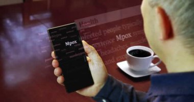 Mpox maymun hastalığı salgını akıllı telefondan okunuyor. Adam uluslararası medyada manşet haberi okudu. Telefondaki haber başlıklarının soyut kavramı.