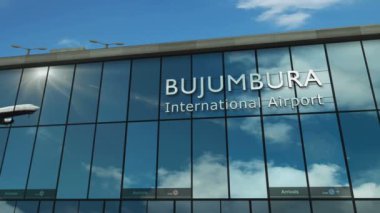 Bujumbura, Burundi 'ye uçak iniyor. Cam havaalanı terminali ve jet uçağının yansımasıyla şehre vardık. Seyahat, iş, turizm ve ulaşım 3D konsepti.